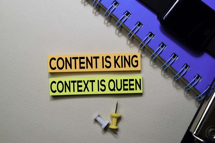 Picture has two cut out pieces of paper in orange and yellow; one reads content is king and the other content in queen