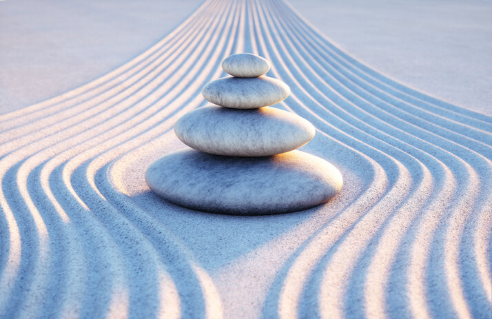 rocks depicting balance on smooth sand