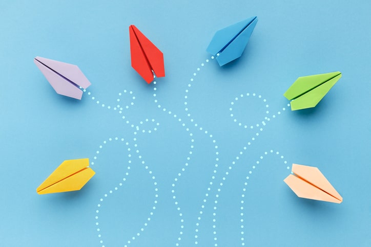 blue background, colorful paper airplanes swirling in various directions