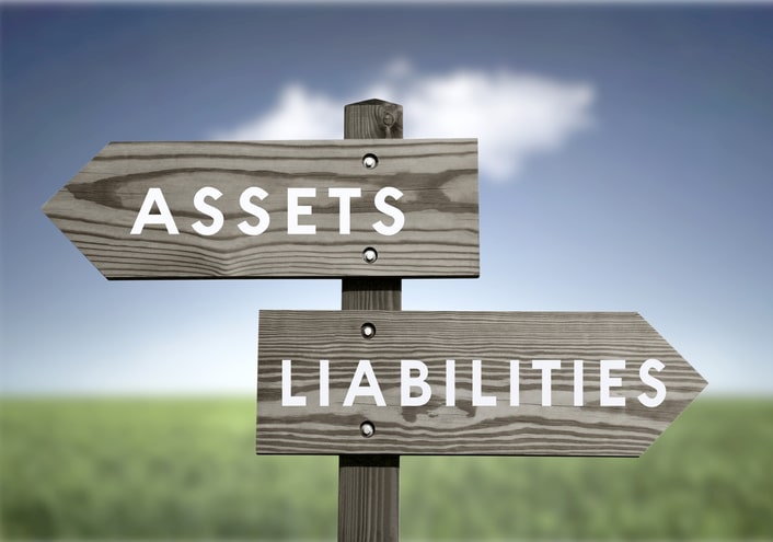 two signs going in different directions with words assets and liabilities
