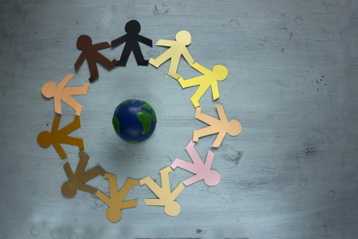paper people around a globe holding hands