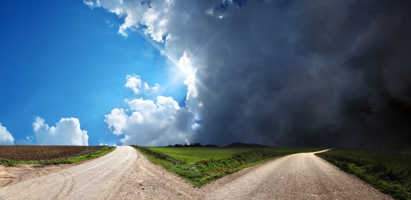 two different paths, one with sunshine and the other looming clouds